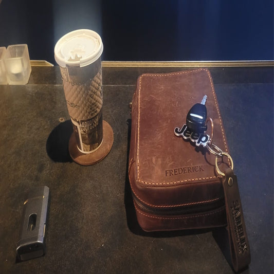 Brown leather wallet with keychain on a dark surface.