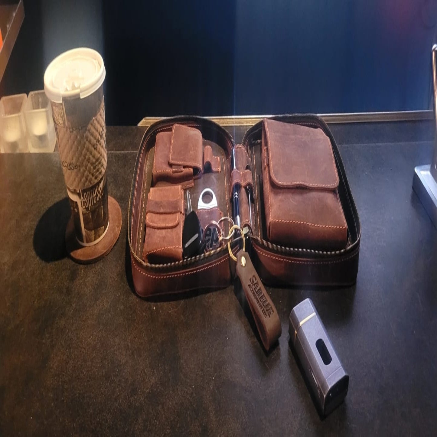Brown leather wallet with keychain on a dark surface.